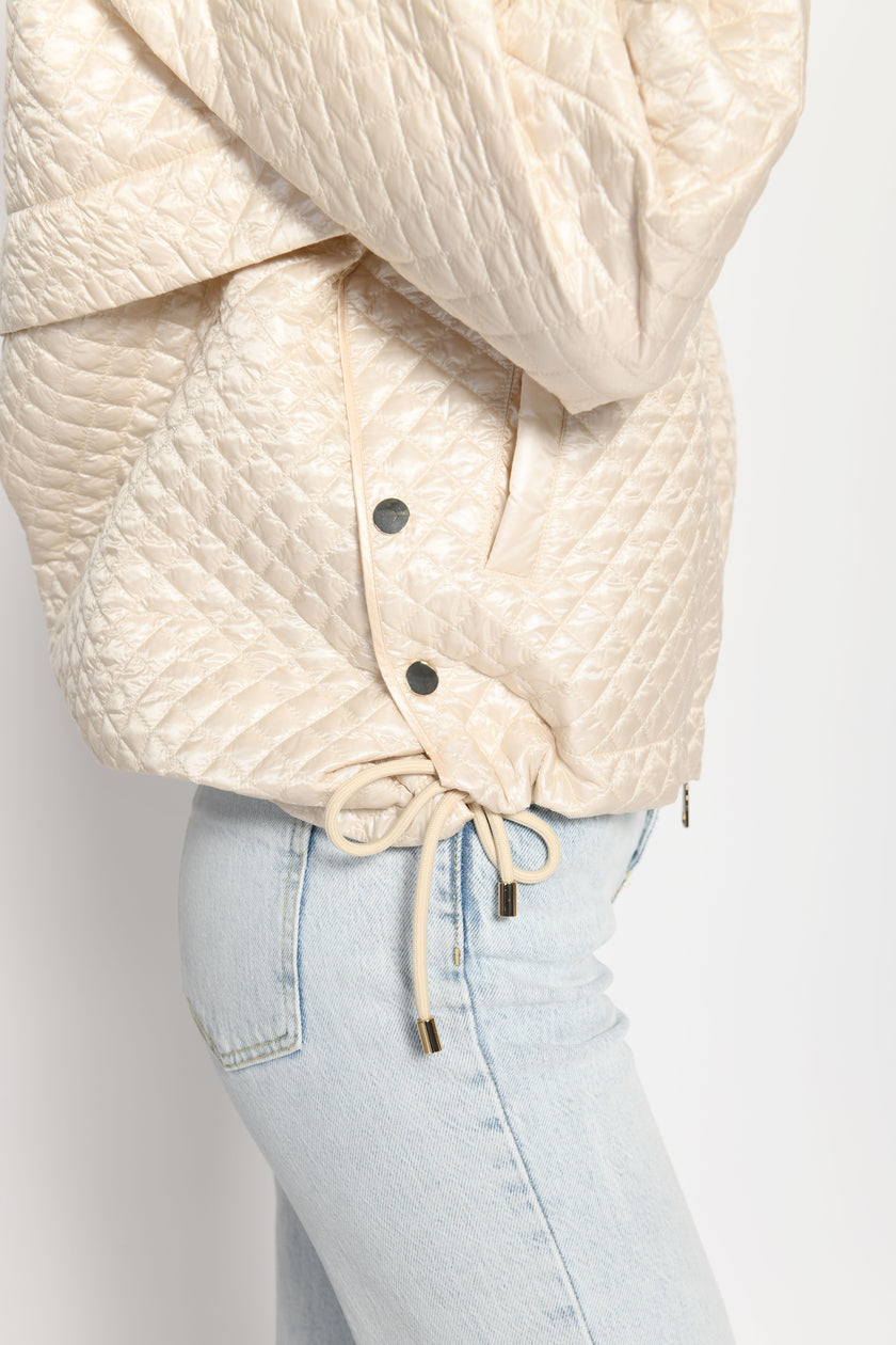 Nahaufnahme des seitlichen Schlitzes inklusive Druckknöpfe der beigen Oversize-Jacke für Damen – Seitenansicht von links