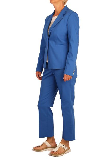 Model trägt blauen zweiteiligen Hosenanzug, bestehend aus Blazer und Hose – stehende Pose, seitliche Ansicht