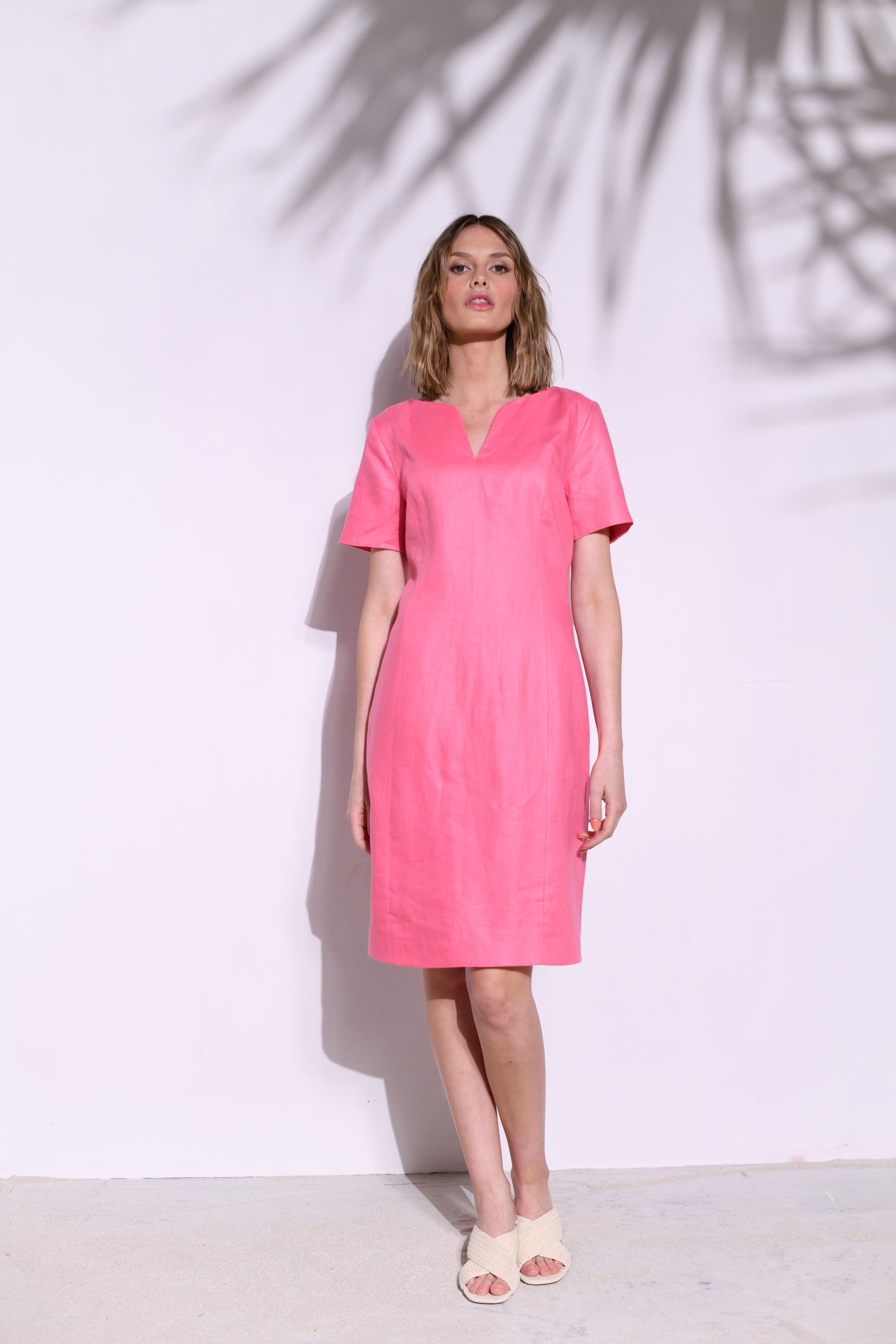 Model trägt tailliertes, knielanges Leinen-Damenetui-Kleid in der kräftigen Farbe Candy – Vorderansicht