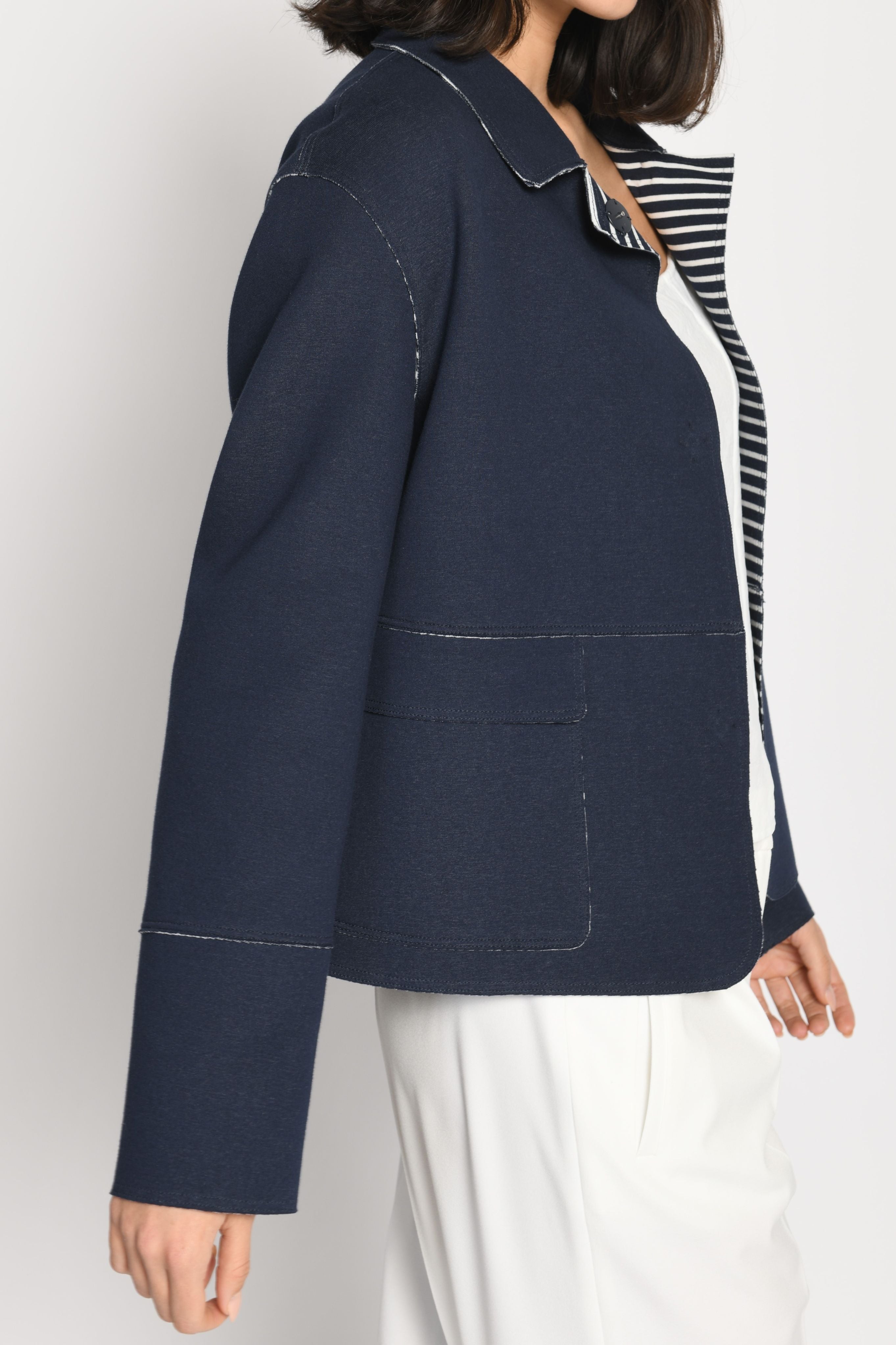 Model trägt Kastenjacke aus Scuba mit kontrastiger Innenseite – Seitenansicht von links