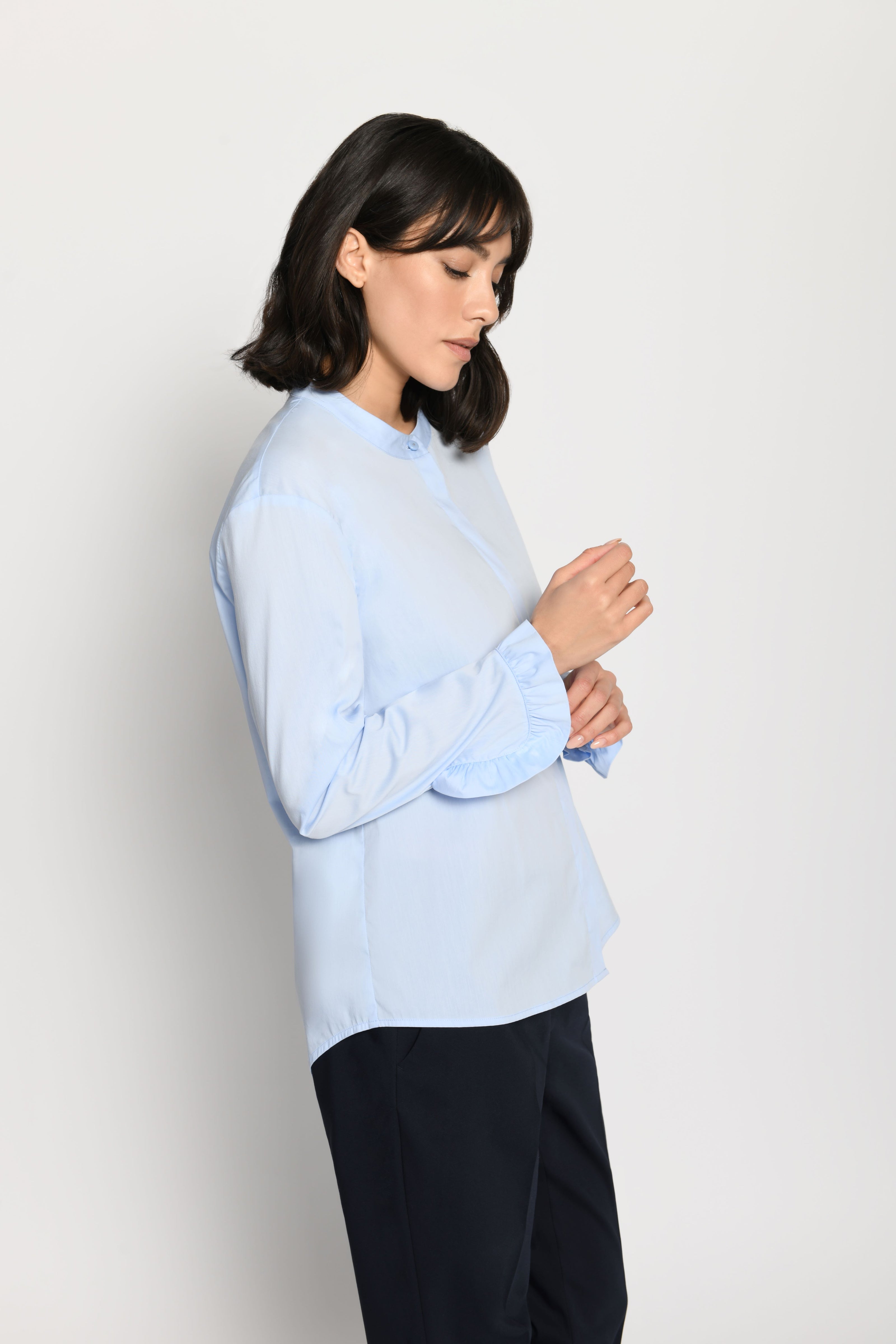 Hellblaue, locker sitzende Damenbluse mit Fokus auf Rüsche am Ärmel – Seitenansicht von links
