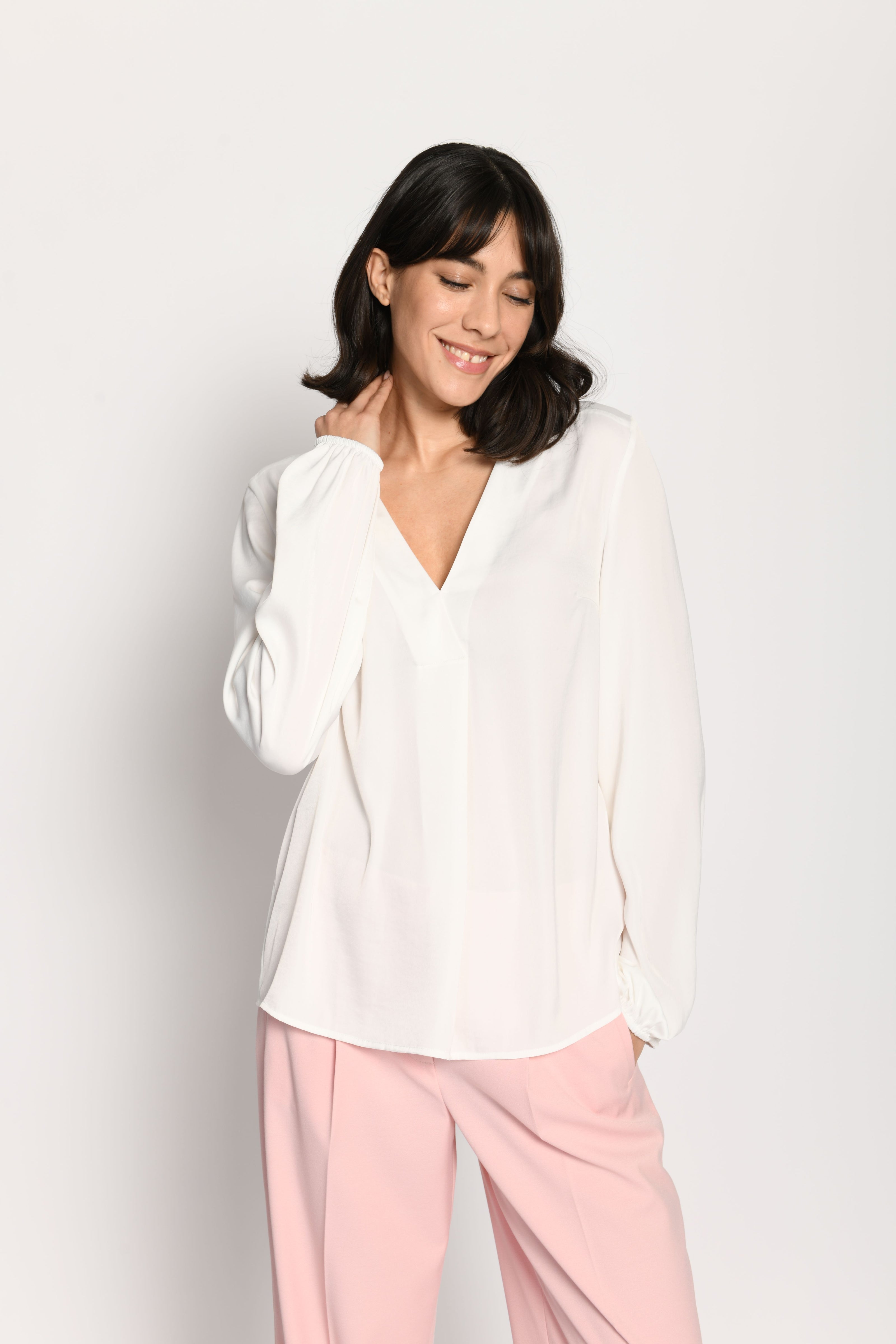 Weiße langärmelige Bluse aus fließendem Material mit V-Ausschnitt – stehende Pose, Blick nach vorne