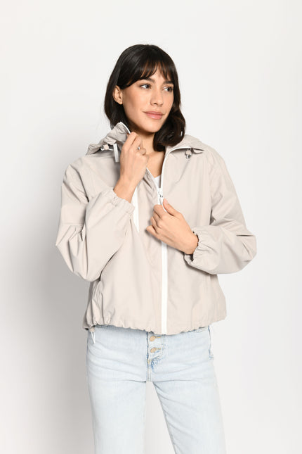 Beigefarbene kurze Outdoor-Kastenjacke mit zwei Reißverschlüssen und Kapuze – Vorderansicht