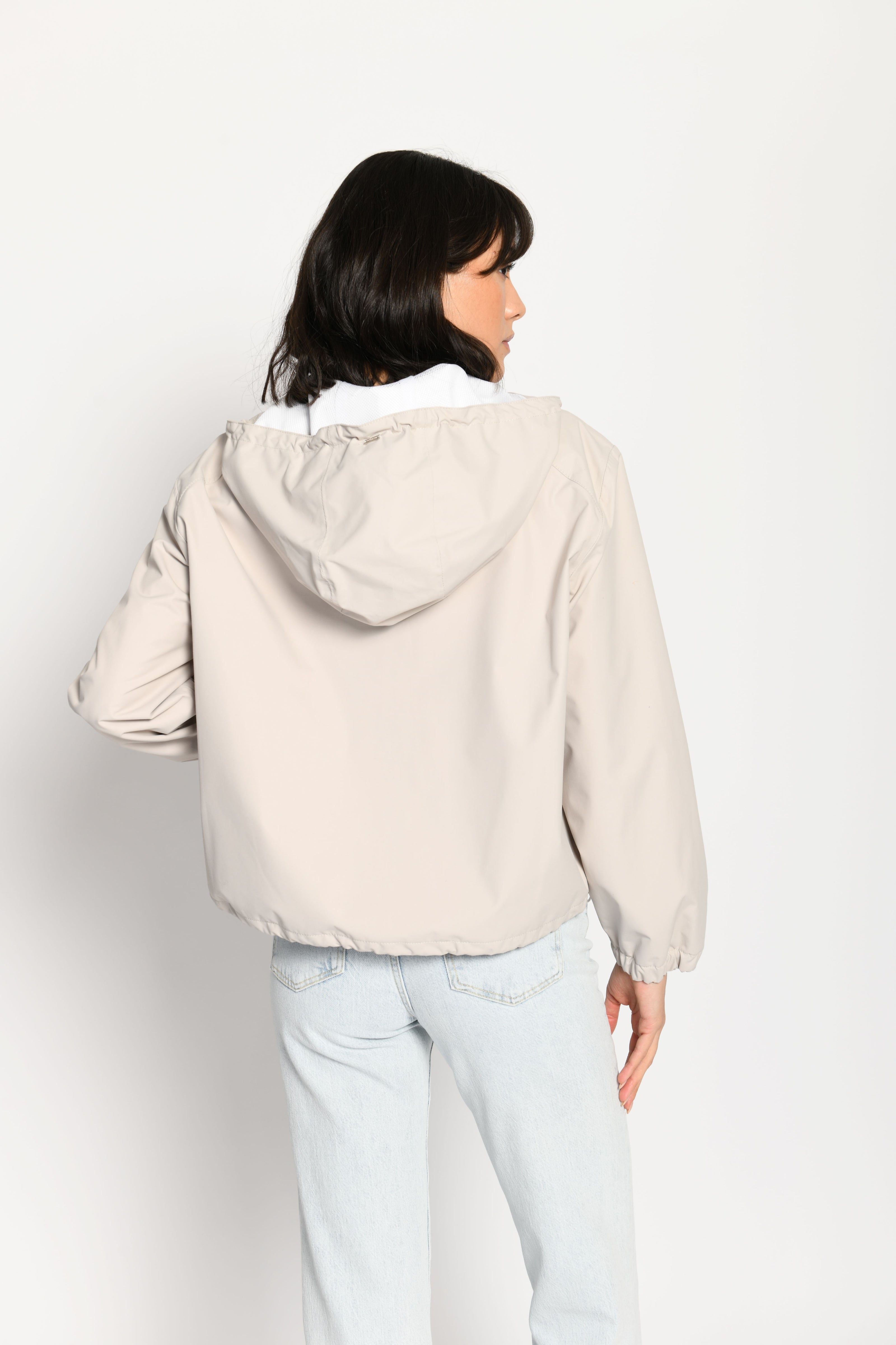 Beigefarbene kurze Outdoor-Kastenjacke mit zwei Reißverschlüssen und Kapuze – Rückansicht
