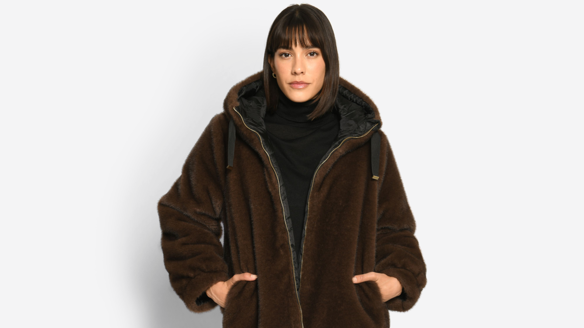 Model trägt eine kuschelige Wendejacke mit Kapuze