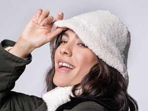 Model trägt weißen, flauschigen Teddy-Fischergut für Damen in Kombination mit hellem Rollkragenpullover – Vorderansicht