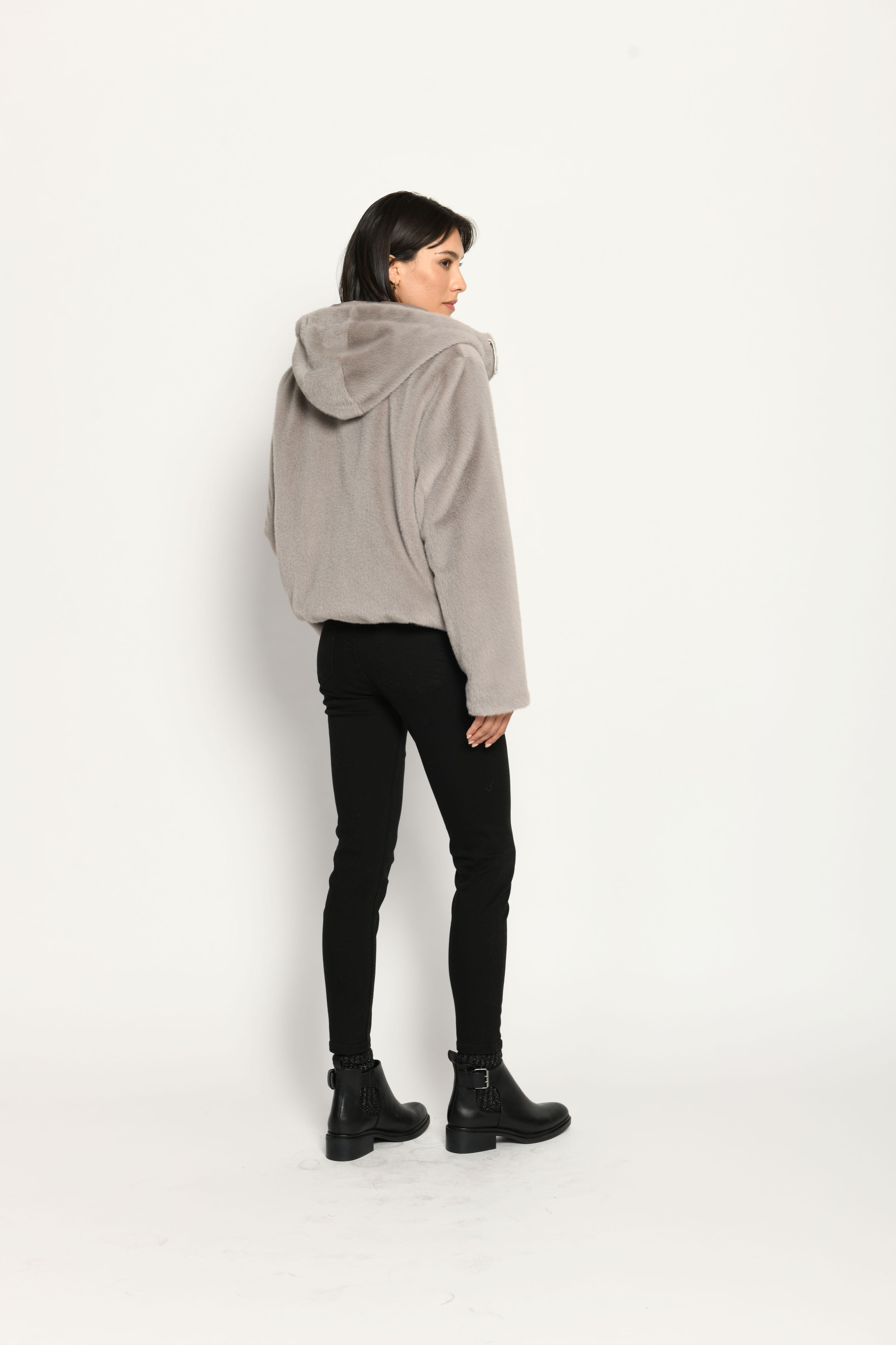 Wendejacke für Damen in der Farbe Taupe mit Webpelz als Außenseite, kombiniert zu schwarzer Jeans – Rücken