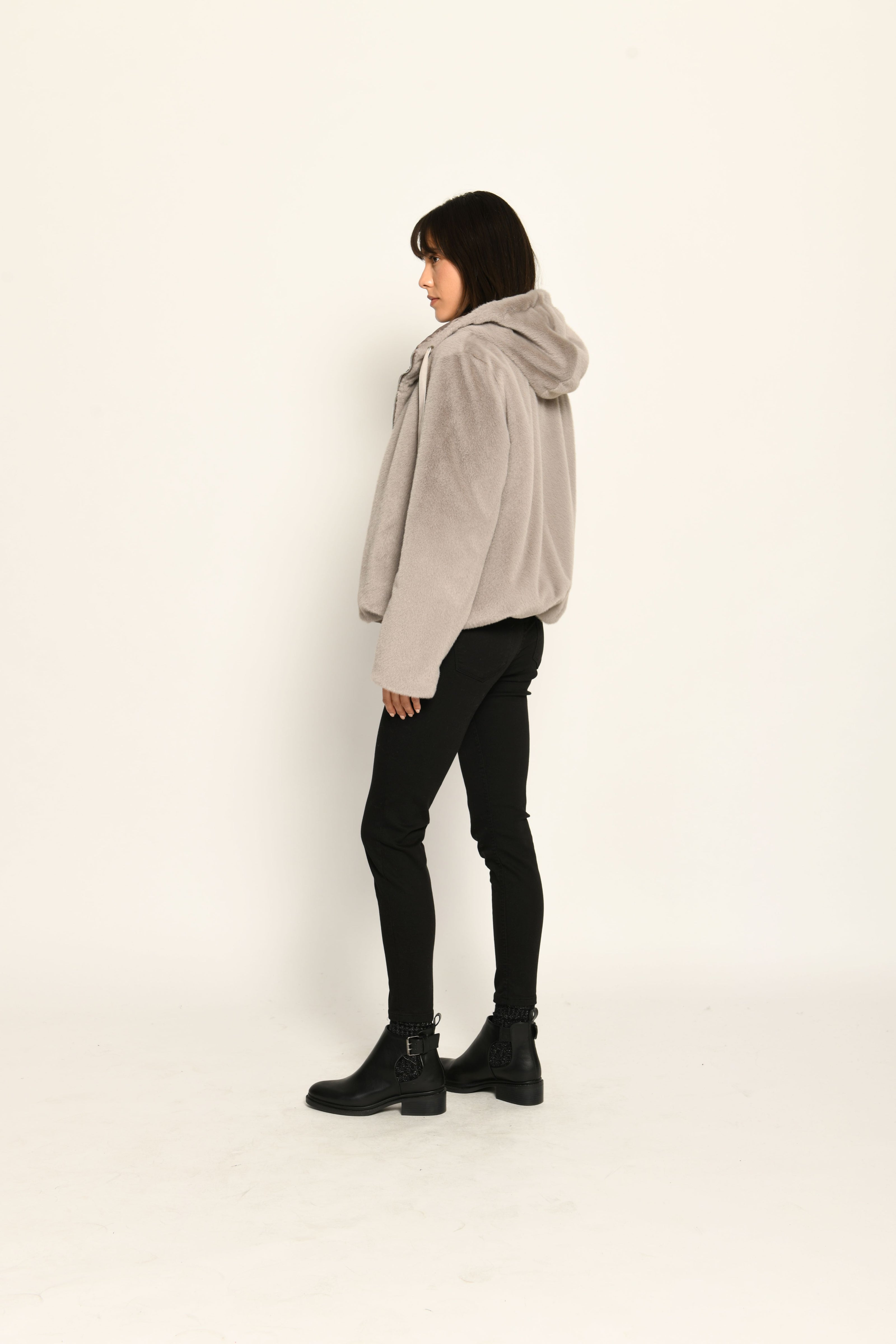 Wendejacke für Damen in der Farbe Taupe mit Webpelz als Außenseite, kombiniert zu schwarzer Jeans – Rückansicht