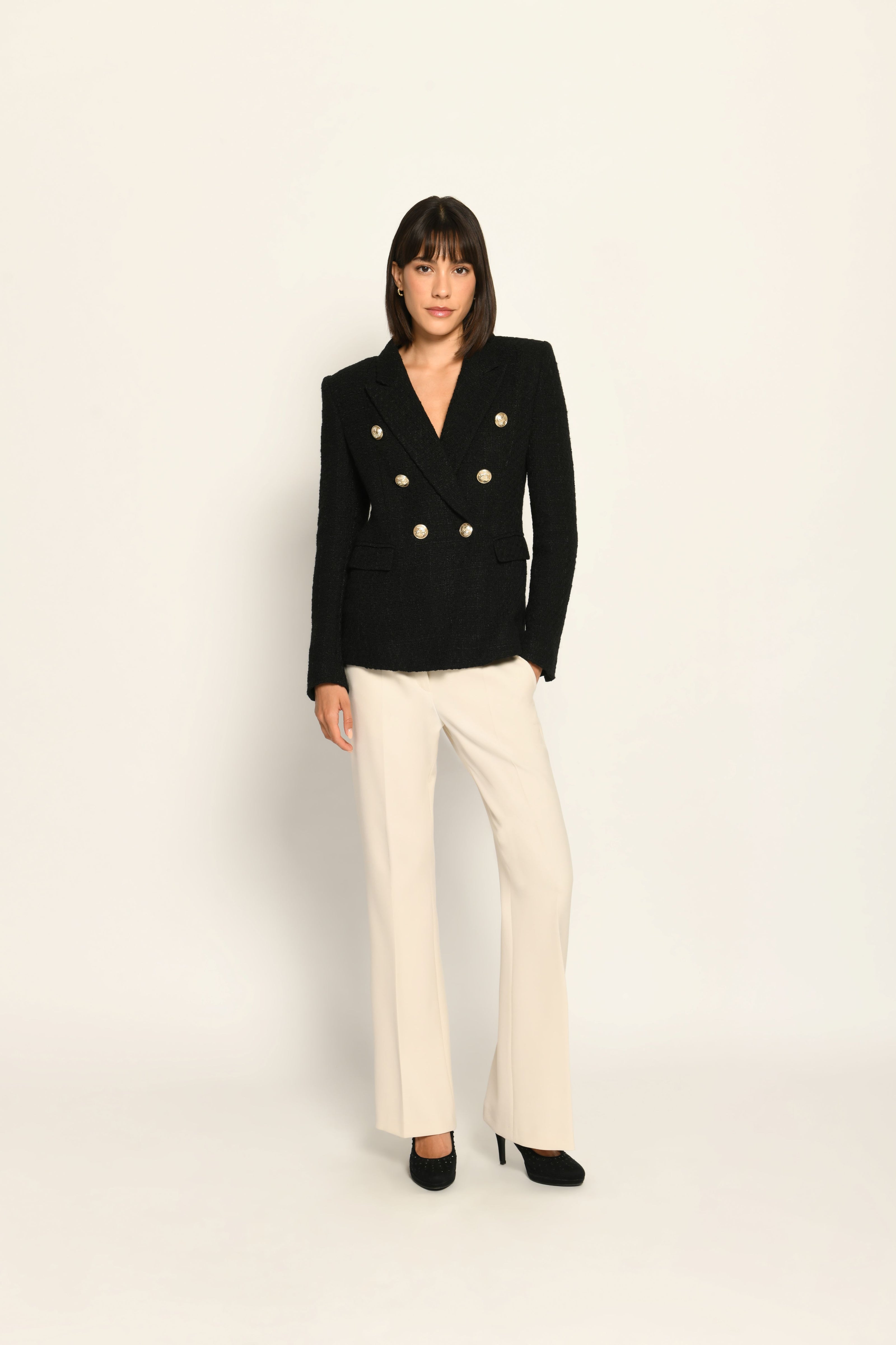 Zweireihiger schwarzer taillierter Bouclé-Blazer für Damen, kombiniert mit beiger Stoffhose – Vorderseite