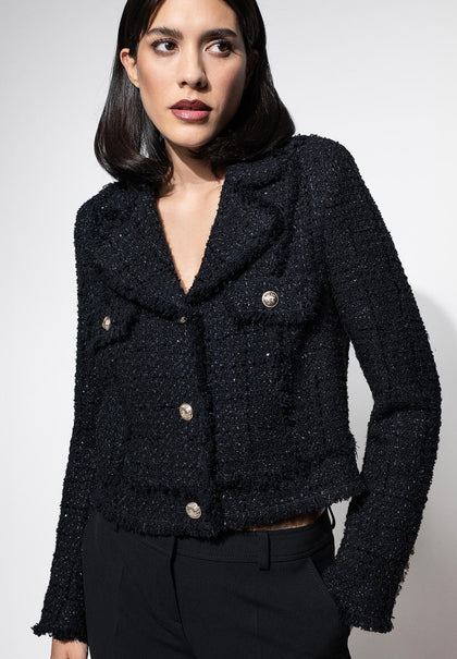 Schwarze taillierte Bouclé-Jacke mit edlen Pailletten für Damen, kombiniert mit schwarzer Stoffhose.