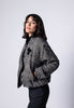 Model trägt Bouclé-Blouson für Damen in den Farben Schwarz und Weiß zu dunkler Stoffhose – Seitenansicht