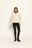 Model trägt oversized geschnittenen cremefarbenen Blouson für Damen zu schwarzer Jeans – Vorderseite