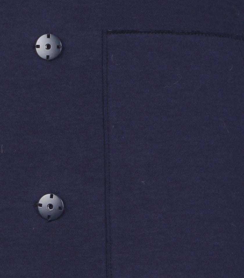 Detailaufnahme zeigt den Anschnitt der aufgesetzten Tasche inklusive Druckknopf auf der Vorderseite.