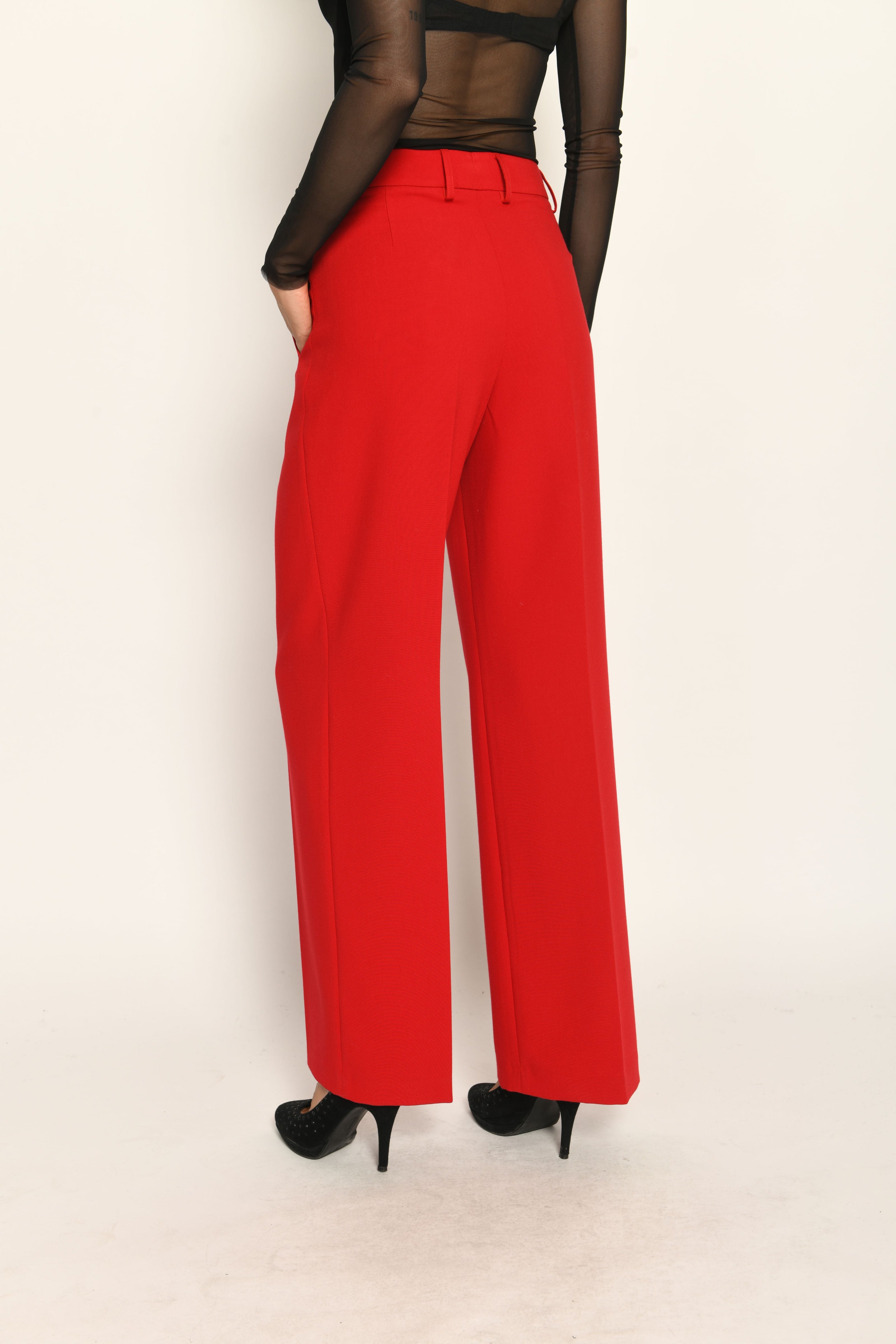 Lange Anzughose für Damen in der Farbe Rot, lässig kombiniert mit schwarzem transparentem Oberteil – Rückansicht.
