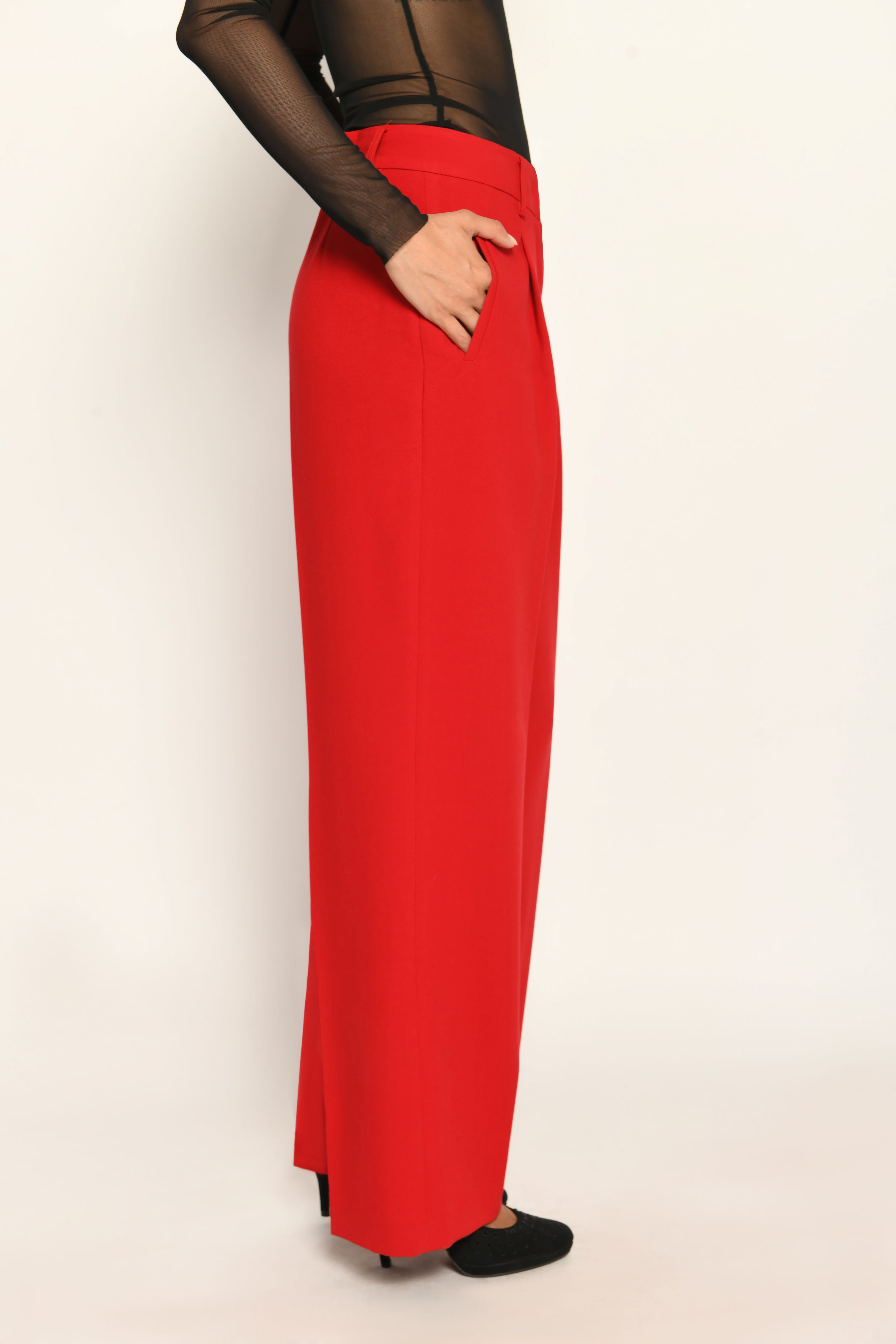 Lange Anzughose für Damen in der Farbe Rot, lässig kombiniert mit schwarzem transparentem Oberteil – Seitenansicht rechts.