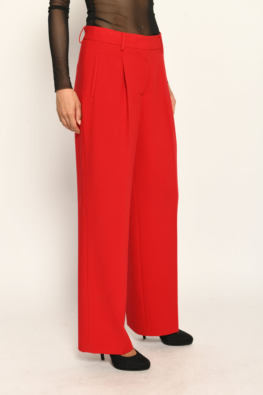 Lange Anzughose für Damen in der Farbe Rot, lässig kombiniert mit schwarzem transparentem Oberteil – Vorderansicht.