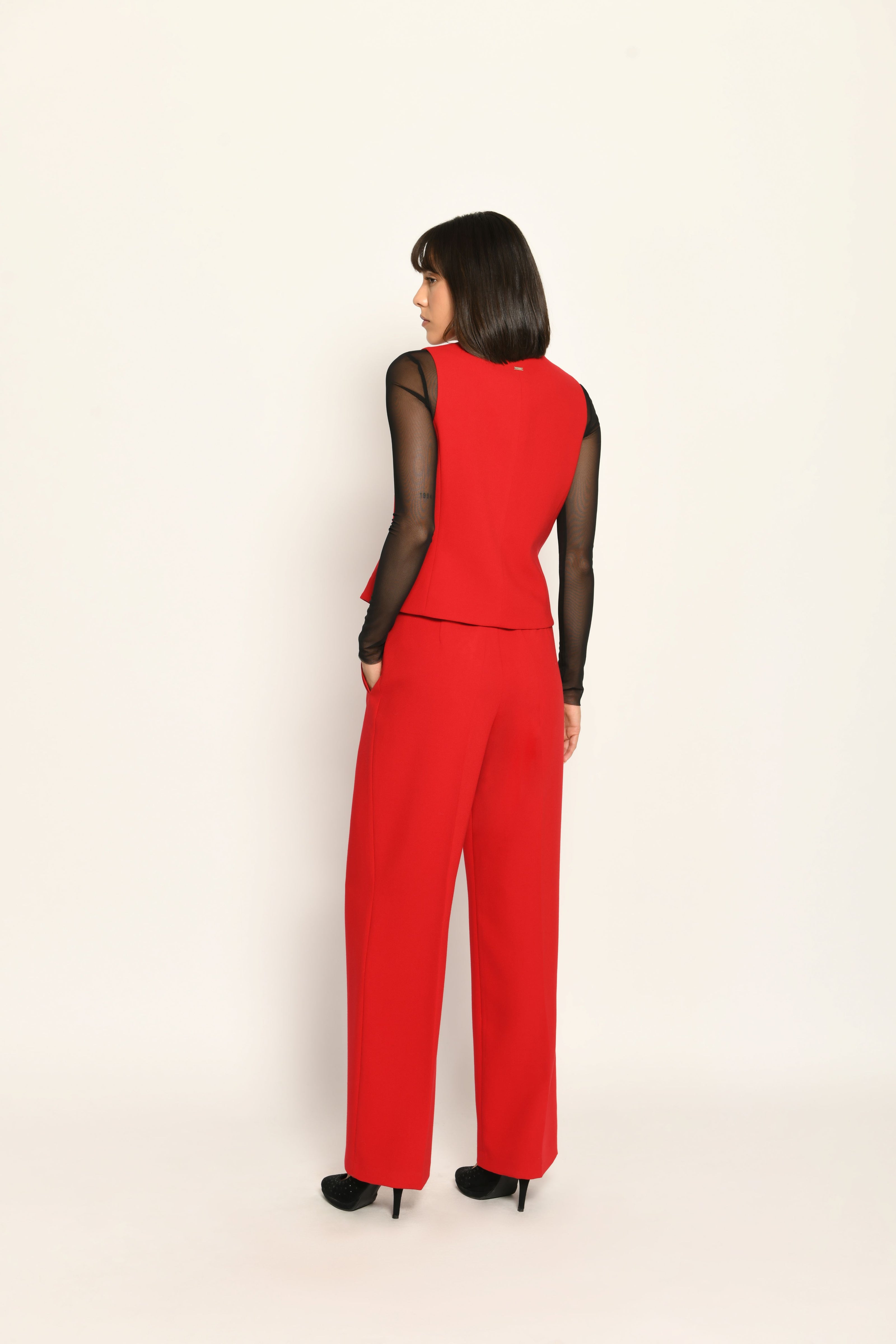 Roter Slim-Fit-Hosenanzug für Damen. Model trägt Weste und lange Stoffhose – Ansicht von hinten.