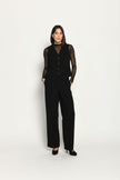 Schwarzer Slim-Fit-Hosenanzug für Damen. Model trägt Weste und lange Stoffhose – Ansicht von vorne.