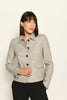 Kurze Slim-Fit-Jacke mit Pepitamuster für Damen, kombiniert mit schwarzer Stoffhose.