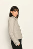 Kurze Slim-Fit-Jacke mit Pepitamuster für Damen, kombiniert mit schwarzer Stoffhose – Nahaufnahme.