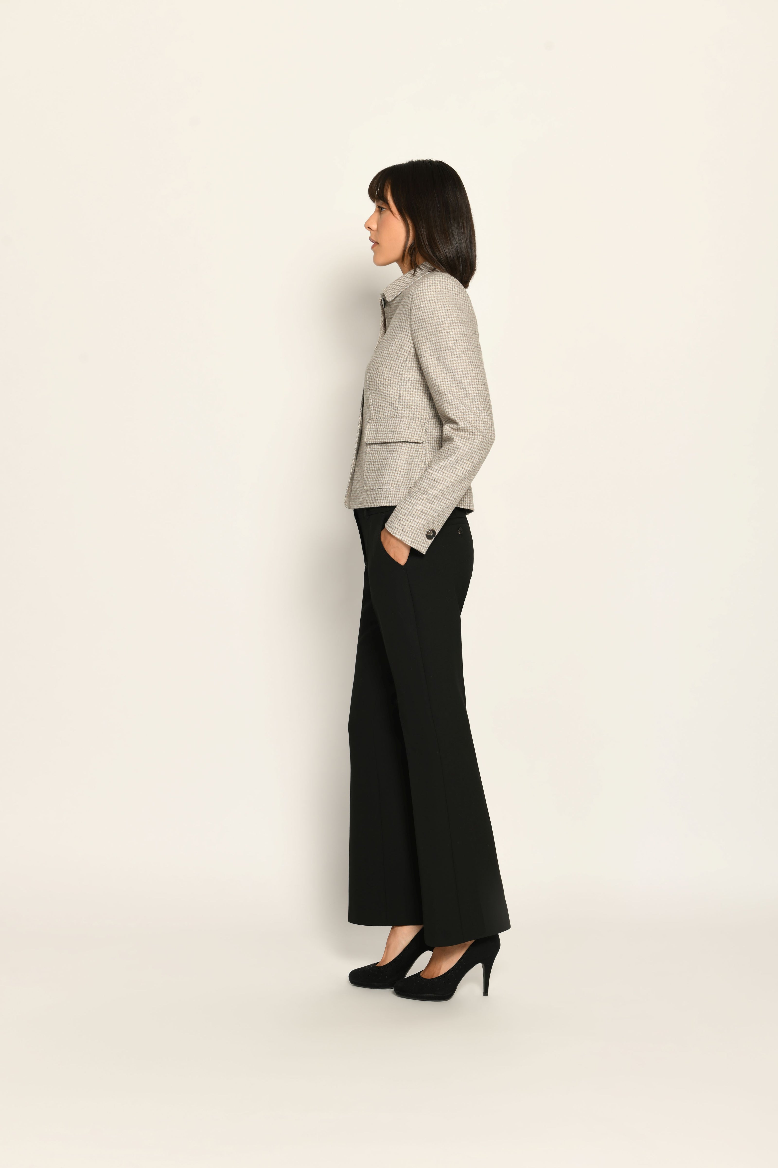Kurze Slim-Fit-Jacke mit Pepitamuster für Damen, kombiniert mit schwarzer Stoffhose – Seitenansicht links