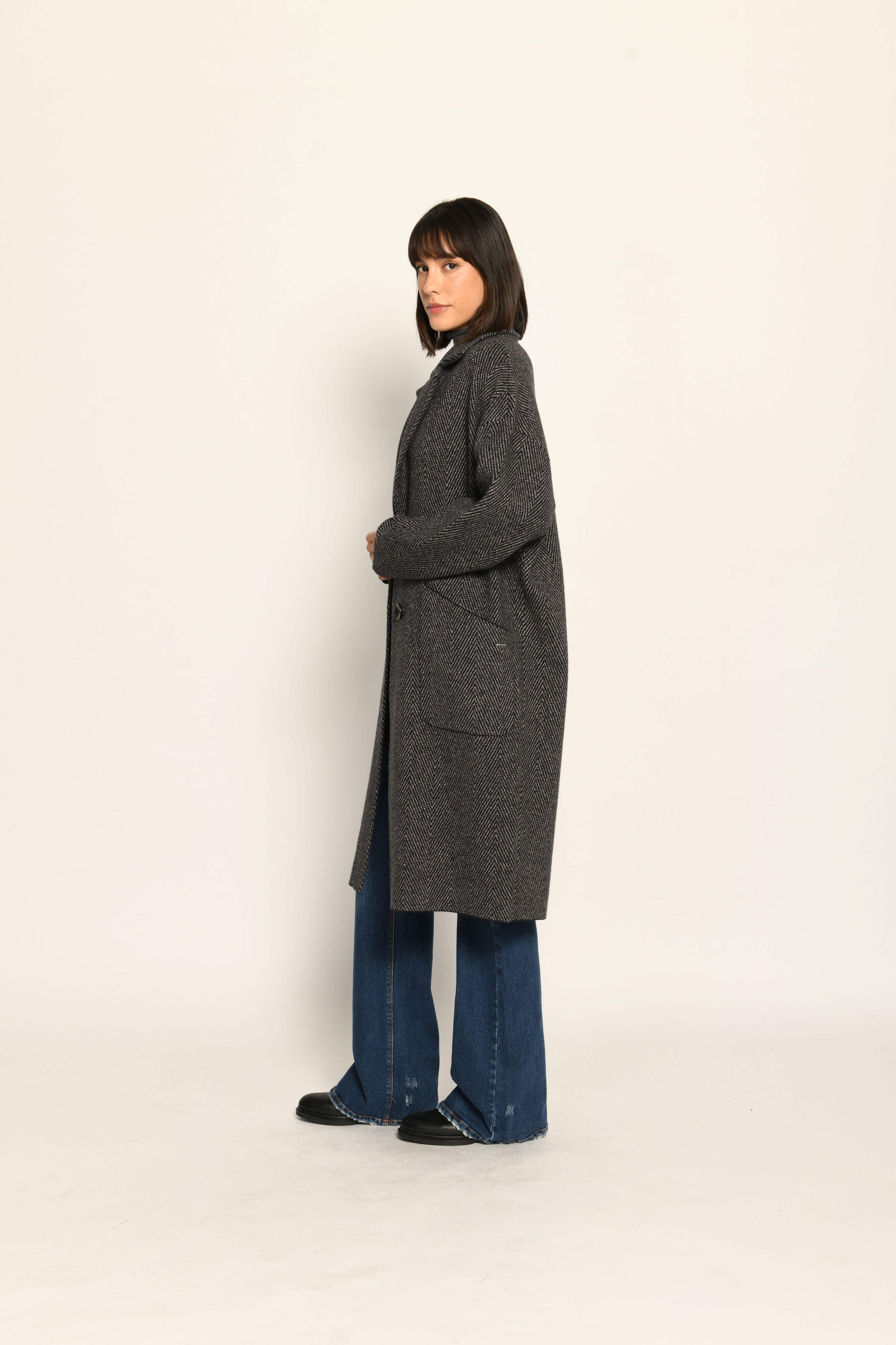 Lässiger Oversize-Strickmantel mit überschnittenen Schultern und Reverskragen, kombiniert zu Jeans.
