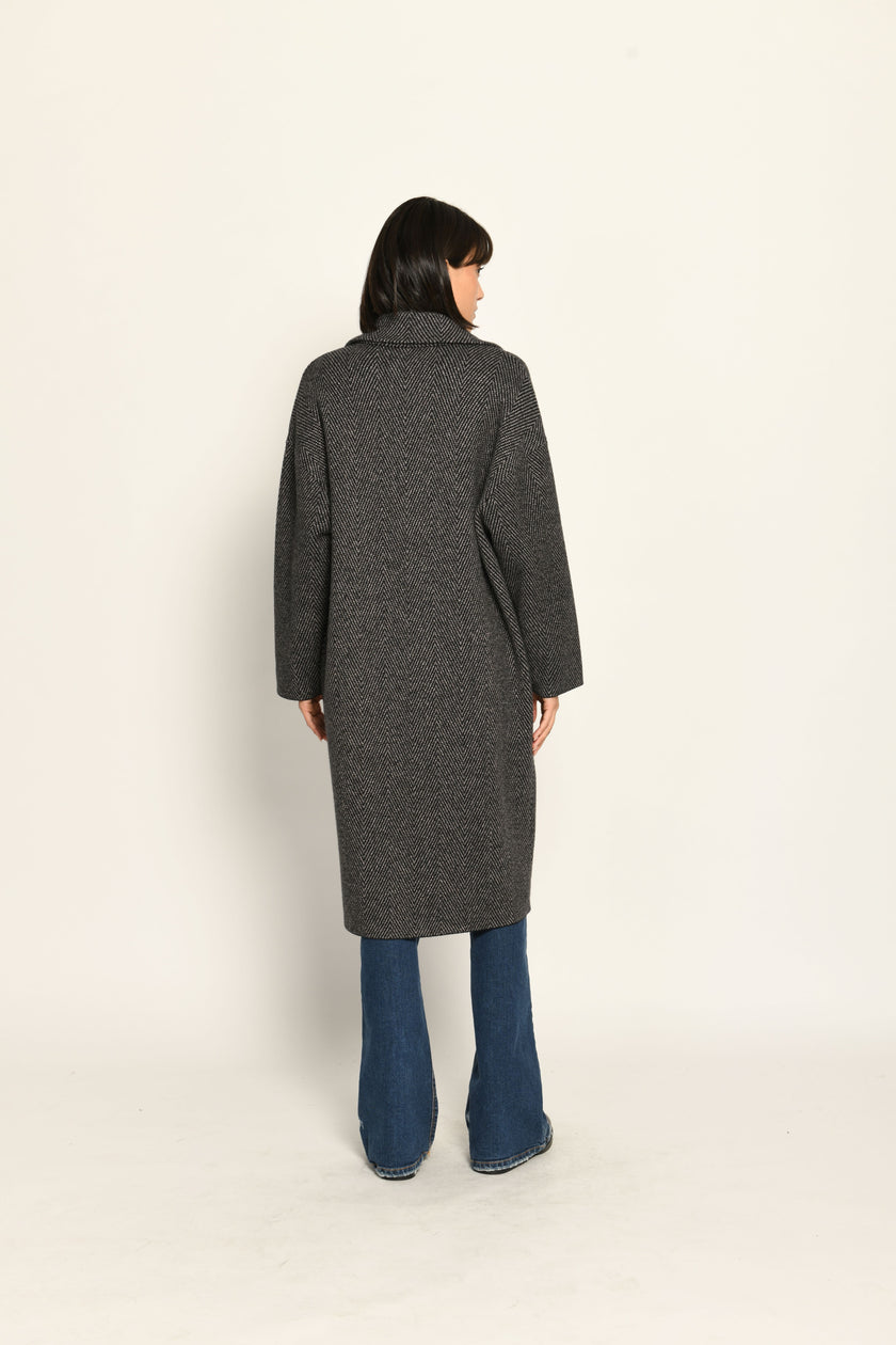 Lässiger Oversize-Strickmantel mit überschnittenen Schultern und Reverskragen, kombiniert zu Jeans – Rückansicht