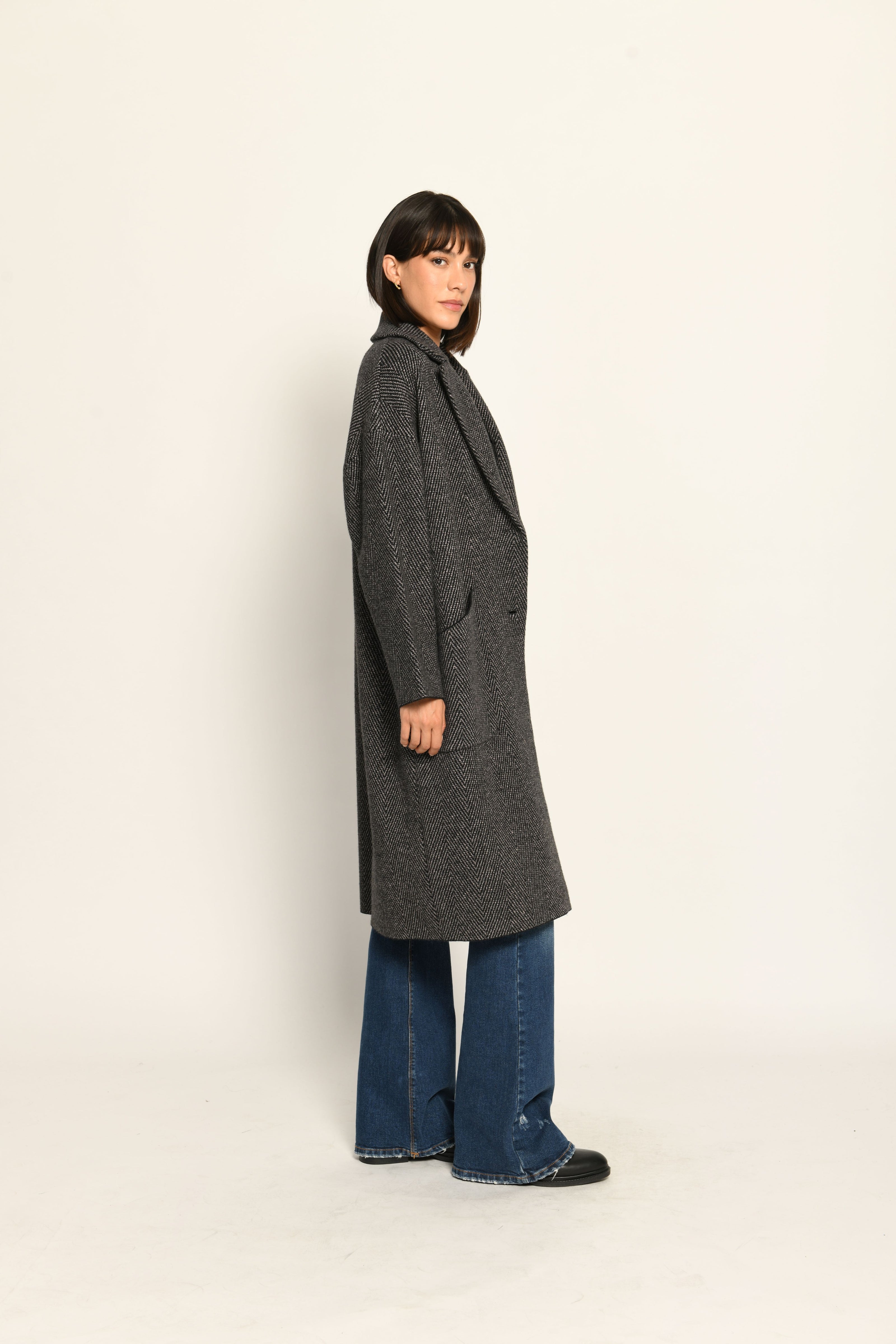 Lässiger Oversize-Strickmantel mit überschnittenen Schultern und Reverskragen, kombiniert zu Jeans – Seitenansicht