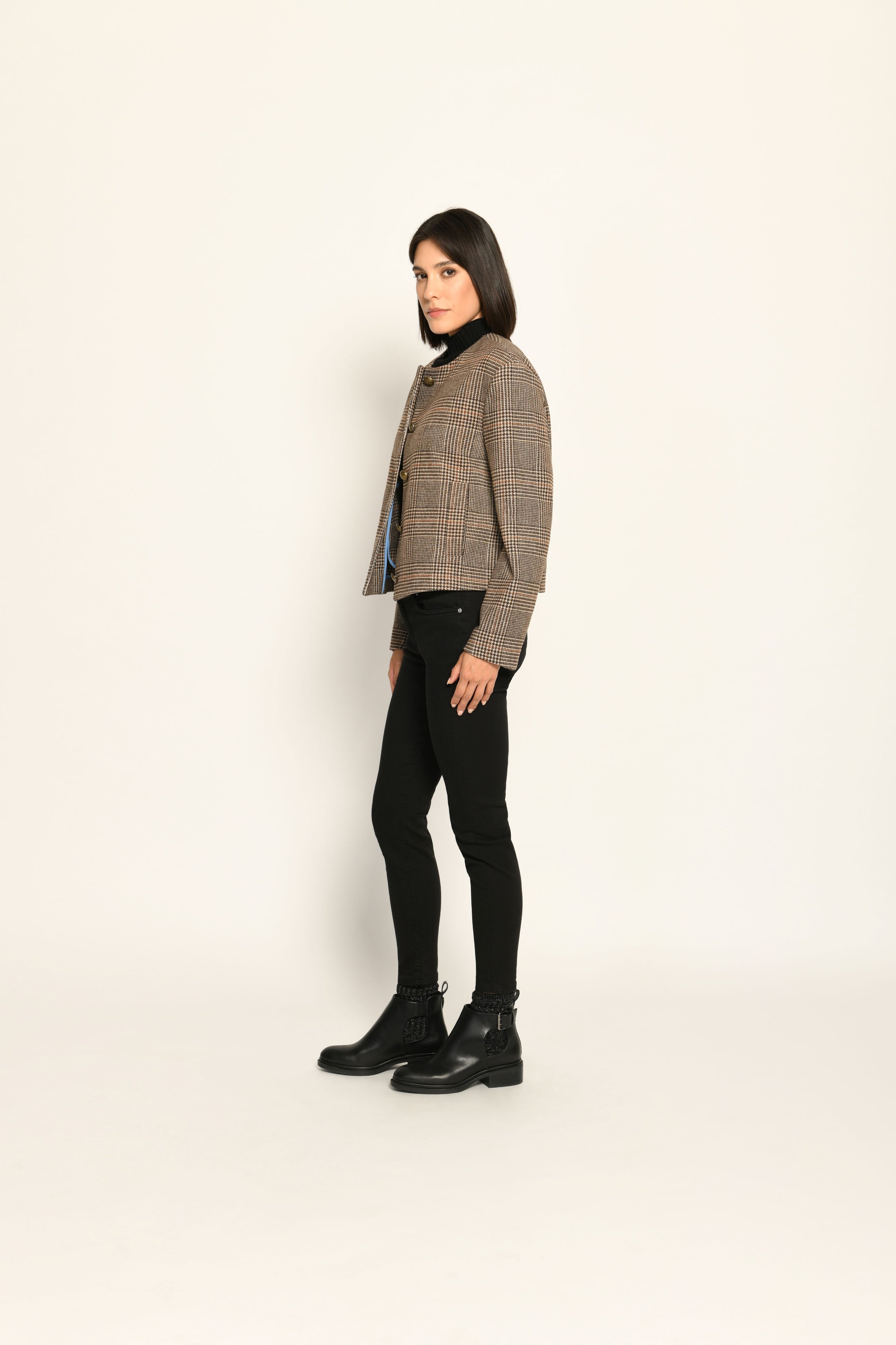 Kurze Kastenjacke für Damen im Glencheck-Dessin mit auffälligen Knöpfen, kombiniert zu schwarzer Hose – linke Seite