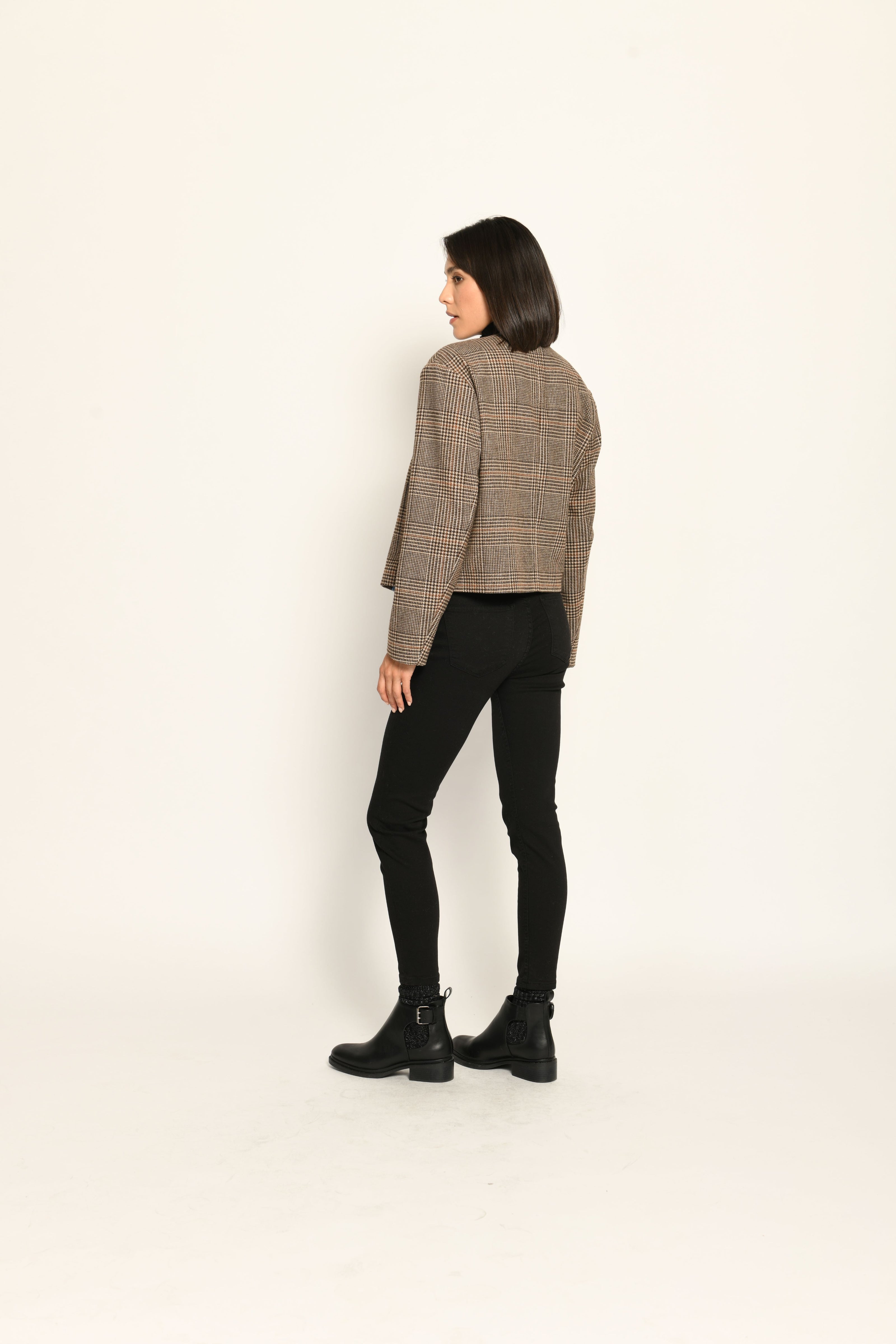 Kurze Kastenjacke für Damen im Glencheck-Dessin mit auffälligen Knöpfen, kombiniert zu schwarzer Hose – Rückansicht