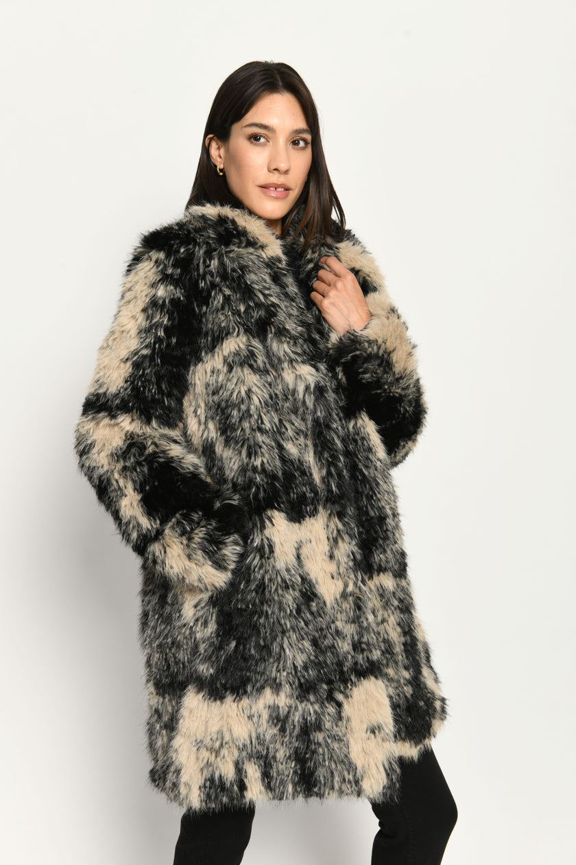 Damenmantel aus langhaarigem schwarz-beigen Webpelz für den Winter – Seitenansicht, geschlossen getragen