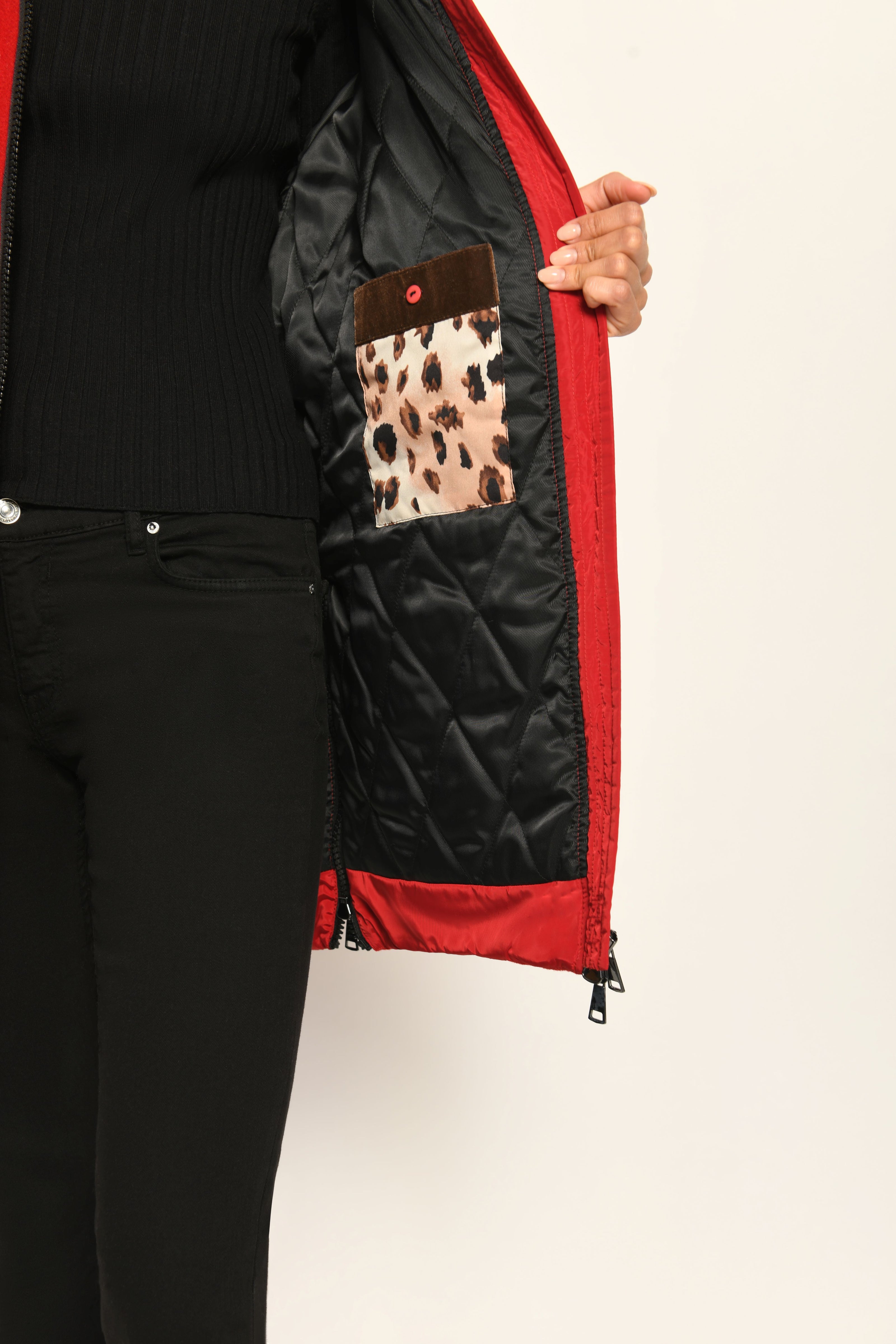 Auf der linken Innenseite des roten Parkas ist eine Tasche im Leo-Dessin mit Knopfverschluss aufgenäht.