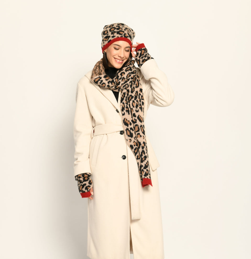 Model trägt Strickmütze, Schal und Stulpen im Leo-Dessin, lässig kombiniert zu einem cremefarbenen Mantel – Vorderansicht - Shop the look