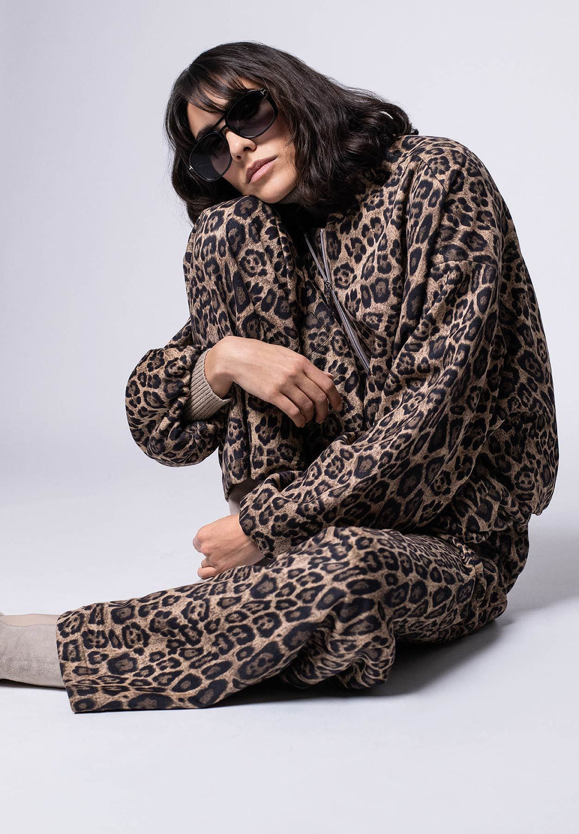 Zweiteiler im Leo-Print für Damen, bestehend aus lässigem Blouson und softer, weiter Hose – Model in lässiger Pose.